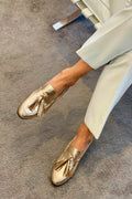 Golden boot with pom-poms