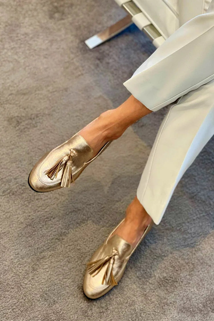 Golden boot with pom-poms