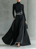 Black maxi dress with white stitching, a high collar, long sleeves, and a narrow waist